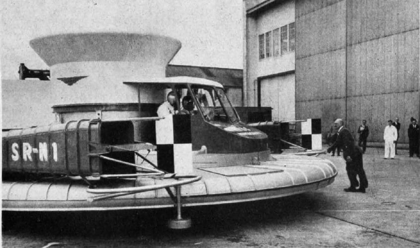 Christopher Cockerell, inventeur de l'aéroglisseur, poussant son prototype de machine